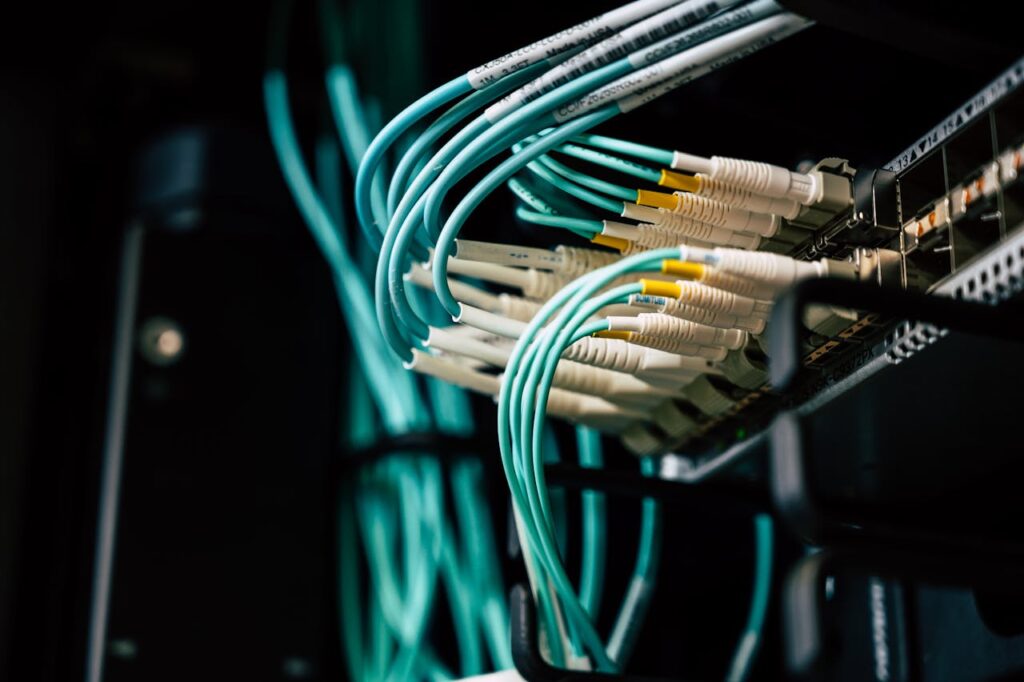 pexels-photo-2881229 Detailed view of network cables plugged into a server rack in a data center.